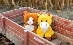 An image of Kiwi the Kitten and George the Giraffe sitting in a wagon