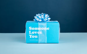 Image of signature Someone Loves You box with a bow wrapped around it