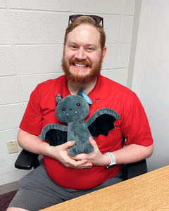 Photo of person smiling while holding black Binks the Bat plushie