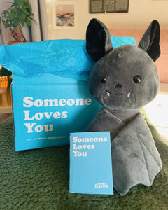 Photo of black Binks the Bat plushie, Someone Loves You box, and note card