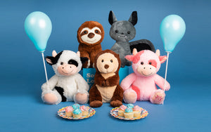 five stuffed animals holding balloons with cupcakes on plates