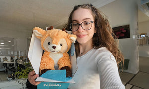woman holding deer stuffed animal in care package box