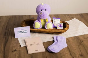 purple dinosaur stuffed animal with self care accesories