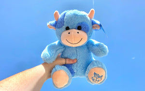 person holding a blueberry cow stuffed animal