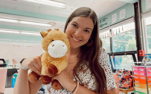 An image of a woman smiling holding George the Giraffe 