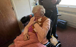 Image of an older woman hugging Kiwi the Kitten