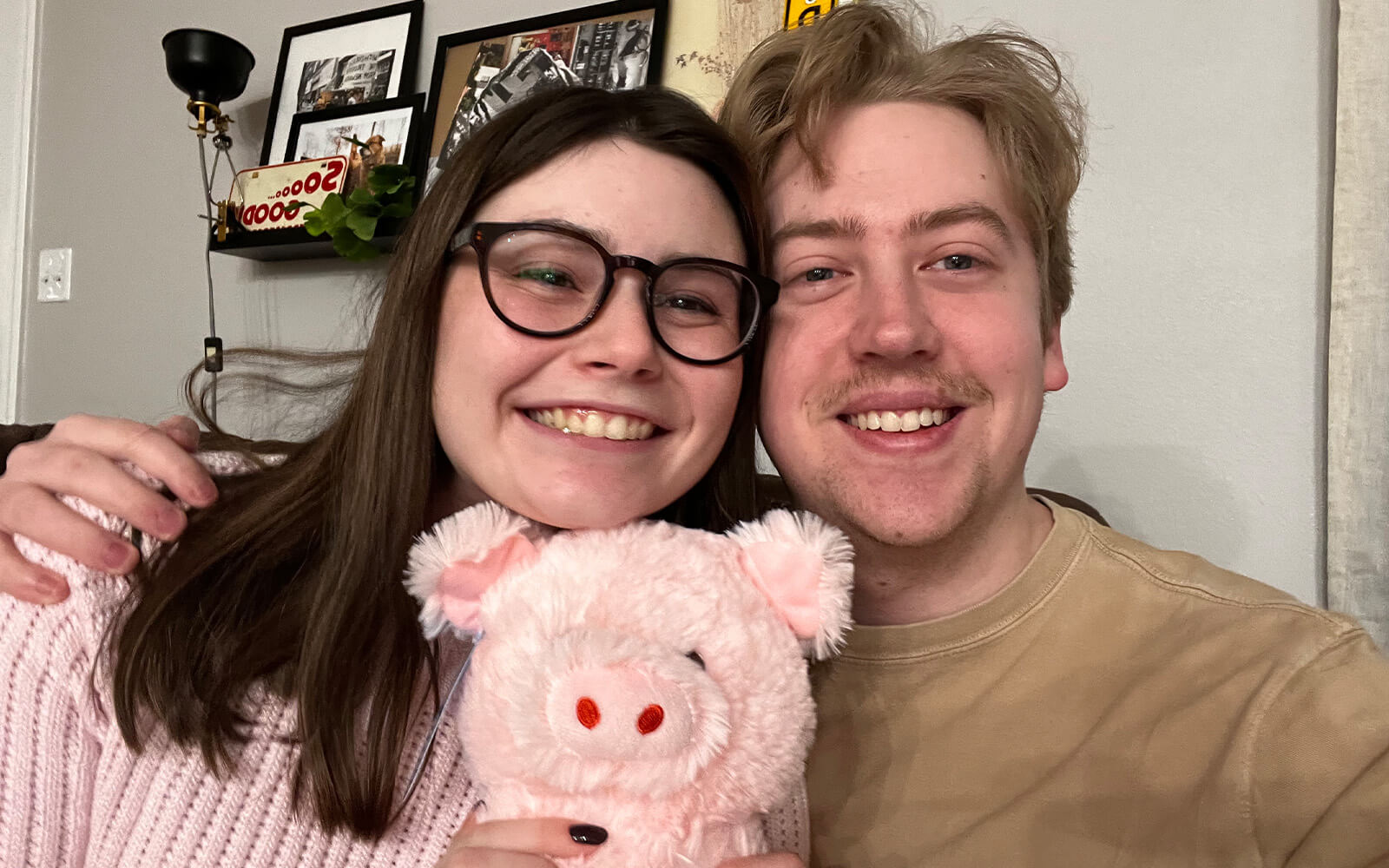 Photo of a couple smiling holding Penny the Pig