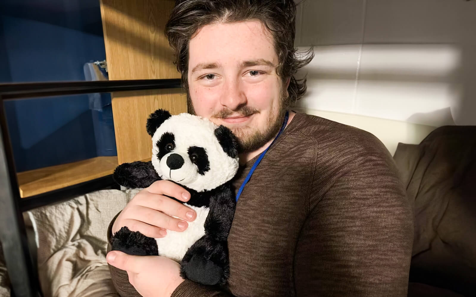 Man smiling while hugging Pokey the Panda