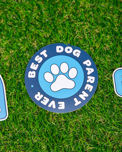 Photo of blue circle shaped sticker. Sticker has paw on it and reads "Best Dog Parent Ever"