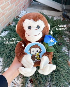 Photo of hand holding Maria the Monkey plushie. Also pictured: matching sticker and blue rose, each available for additional $3