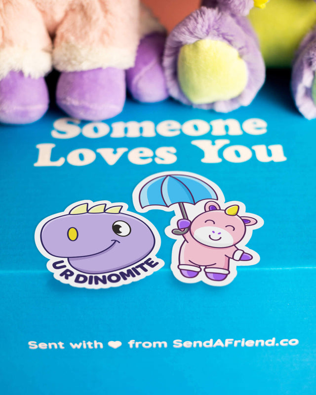 Photo of Unique the Unicorn and Dexter the Dino stickers sitting on Someone Loves you box.
