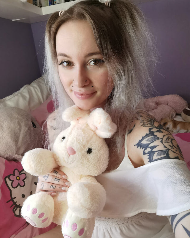 Person taking selfie with white Benny the Bunny plushie