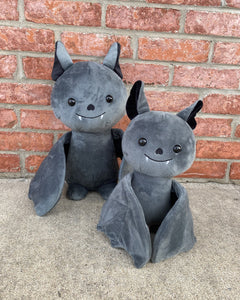 Photo of 10 inch and 14 inch black Binks the Bat plushies with brick wall in the background