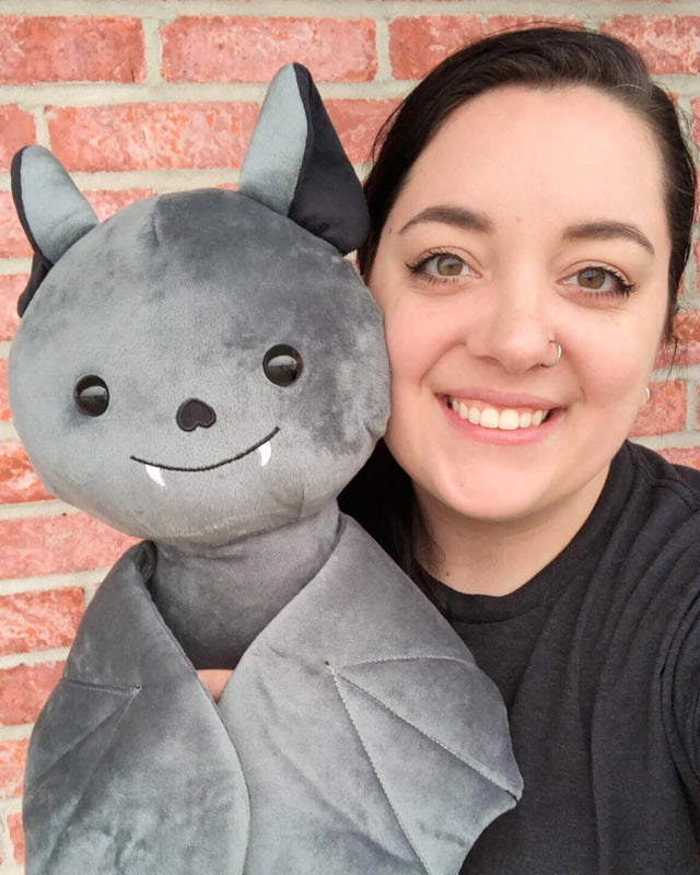 Photo of person smiling holding 14 inch Jumbo Binks the Bat plushie next to face